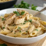 Creamy garlic parmesan chicken pasta in a bowl, garnished with parsley and parmesan cheese.